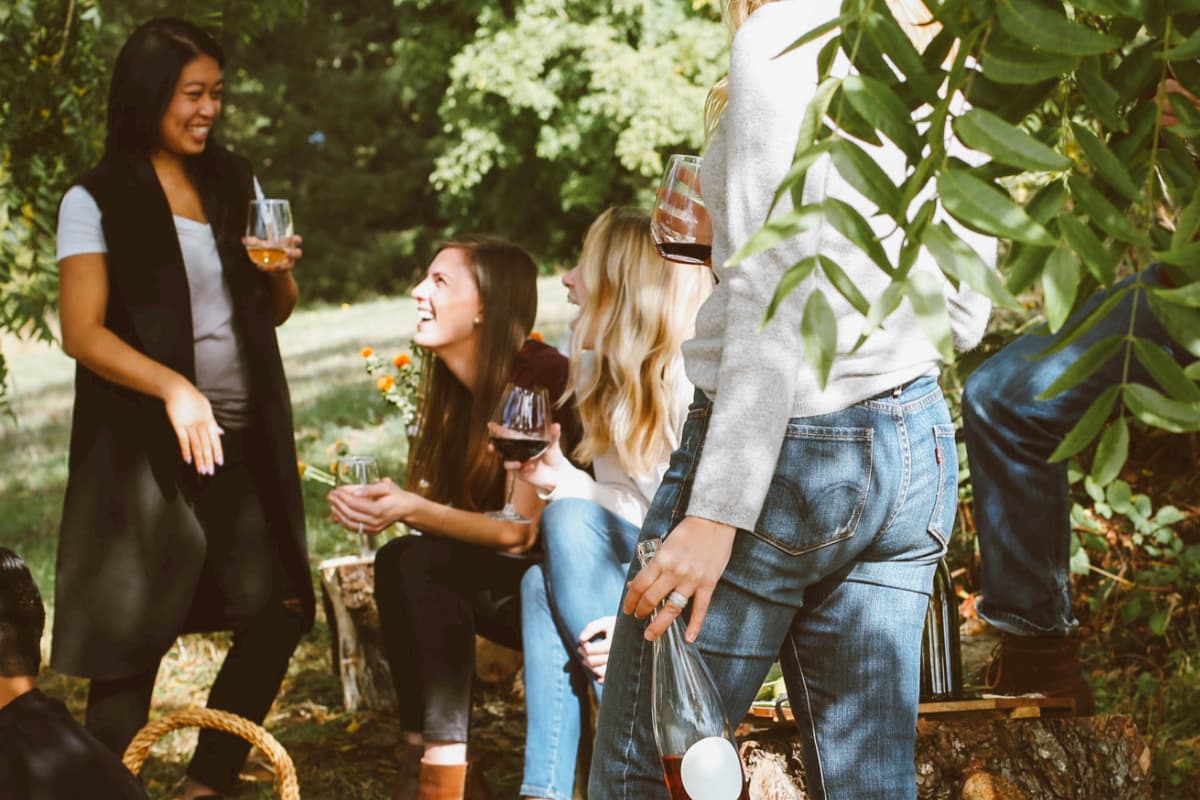 young women in a forest enjoying a drink and a laugh